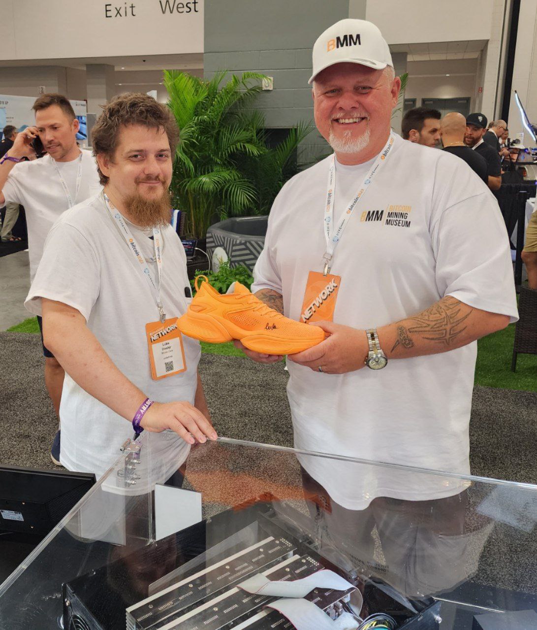 TheCoinDad holding a rare pair of Bitcoin orange McLarenF1 sneakers with Bitcoin Core developer Luke Dashjr